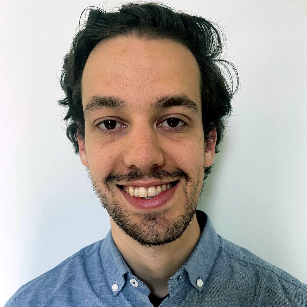 Headshot of Caleb smiling at the camera against a white background