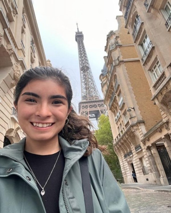 Daphne smiling at the camera with the Effiel Tower in the back