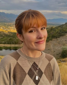 Kira smiling at the camera with rolling hills in the background